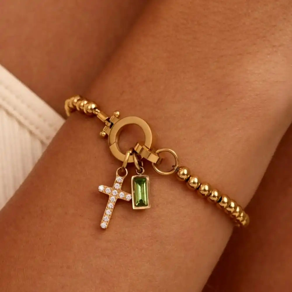 Armbånd med kors og desemberfødselsstein