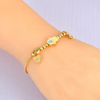 Beskyttelsesarmbånd med Fatmas hånd og blått øye gull