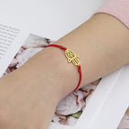 Armbånd i snor med arabisk Fatima-hånd i gull