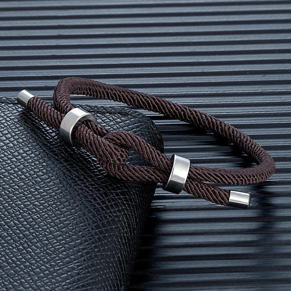 Moderne armbånd i flettet snor med brun knute