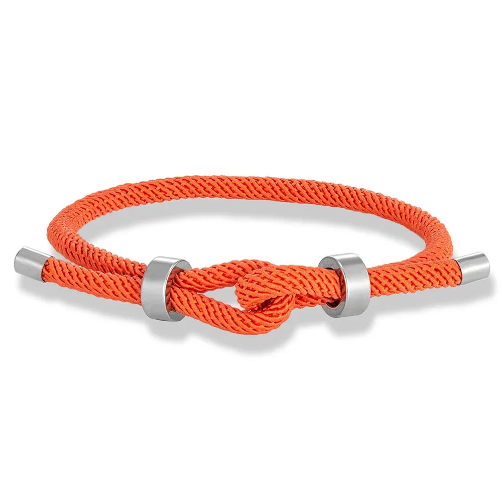 Moderne armbånd i flettet snor med oransje knute