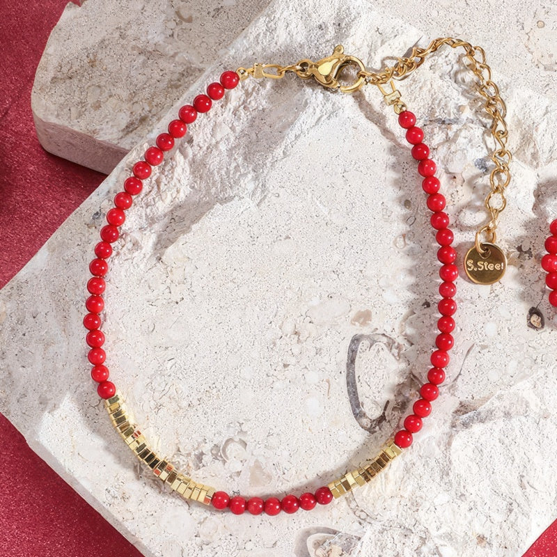 Rött och guldfärgat armband i korall