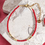 Rött och guldfärgat armband i korall