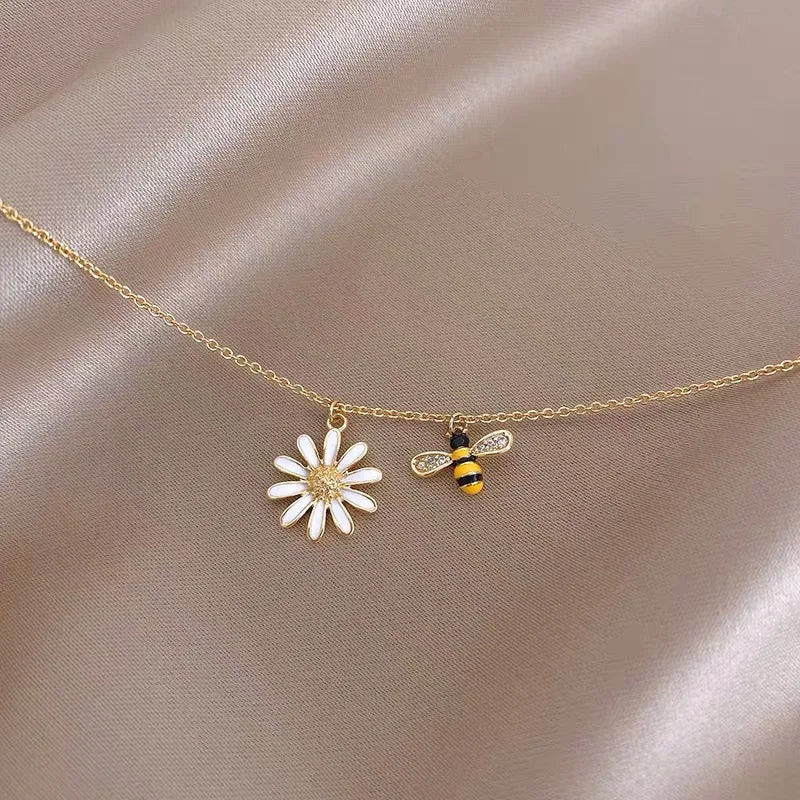 Halsband med hänge i form av ett bi och en tusensköna