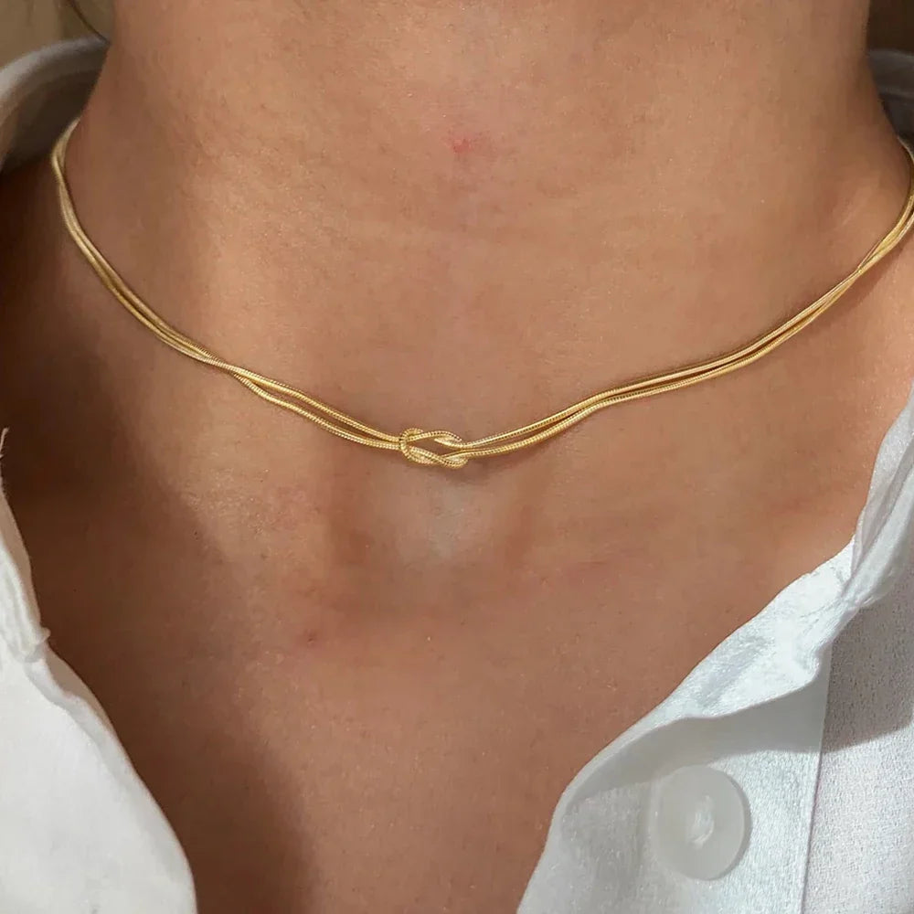 Náhrdelník s minimalistickým uzlovým přívěskem ve zlaté barvě