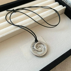 Långt halsband med silverfärgat spiralformat hängsmycke
