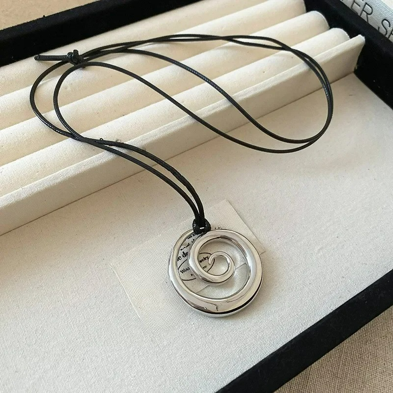 Långt halsband med silverfärgat spiralformat hängsmycke