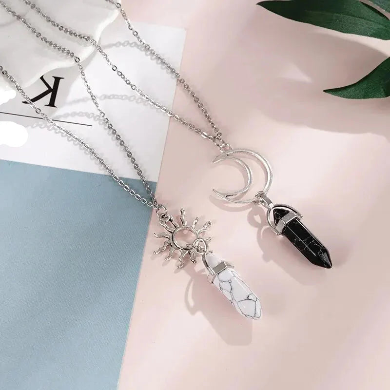 Halsband med hängsmycken i form av månskära och sol