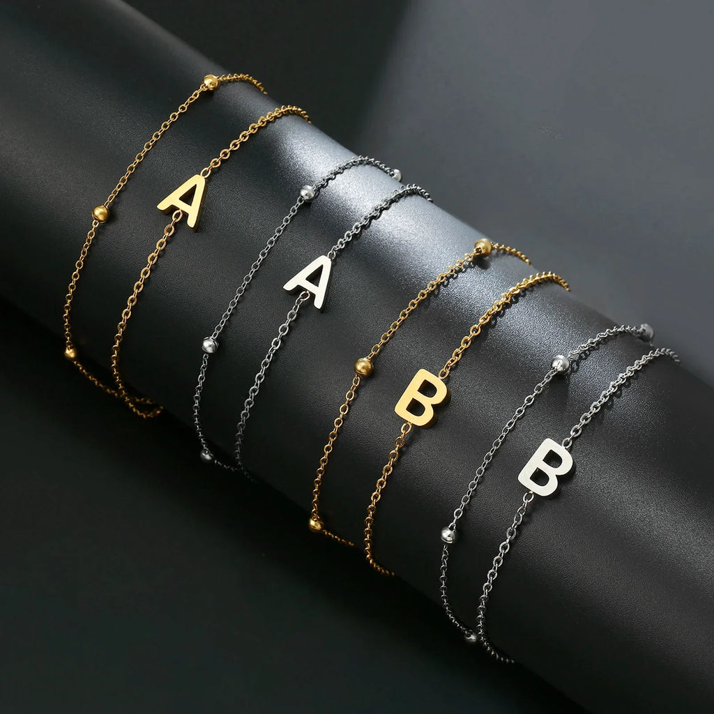 Armband med dubbel initial i guld och silver