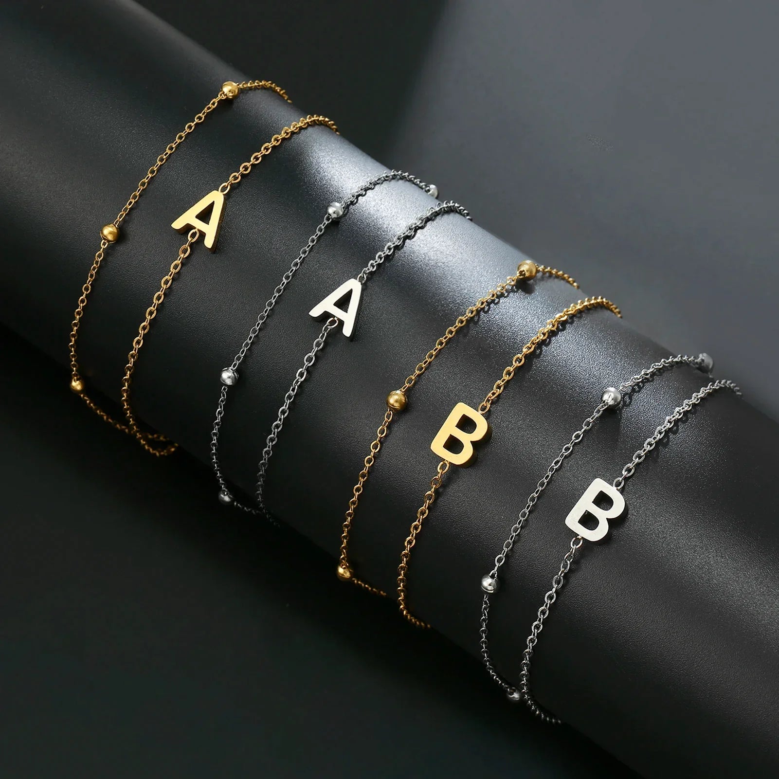 Armband med dubbel initial i guld och silver