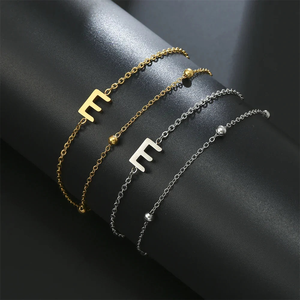 Armband med dubbel initial i guld och silver  e