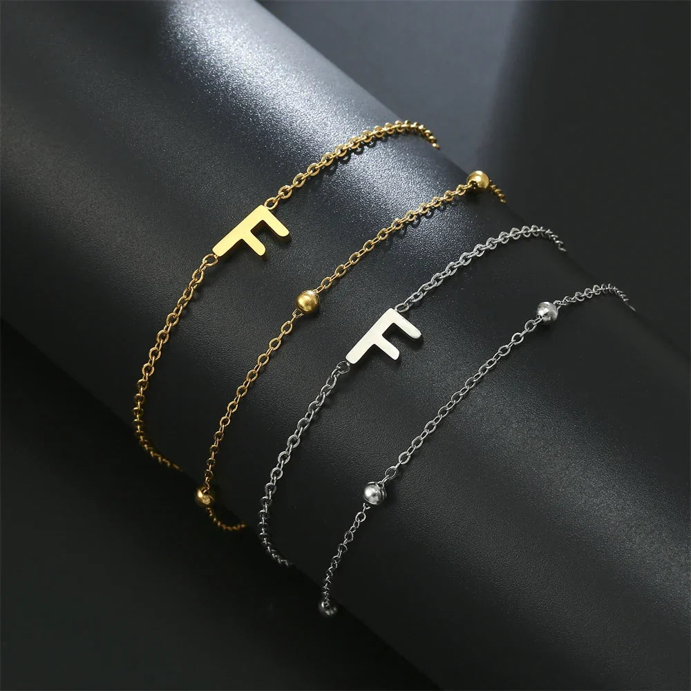 Armband med dubbel initial i guld och silver  f