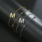 Armband med dubbel initial i guld och silver  m