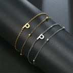 Armband med dubbel initial i guld och silver  p