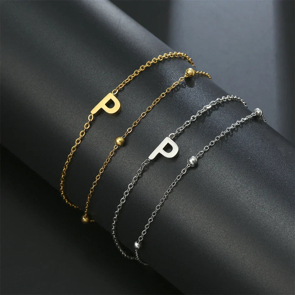 Armband med dubbel initial i guld och silver  p