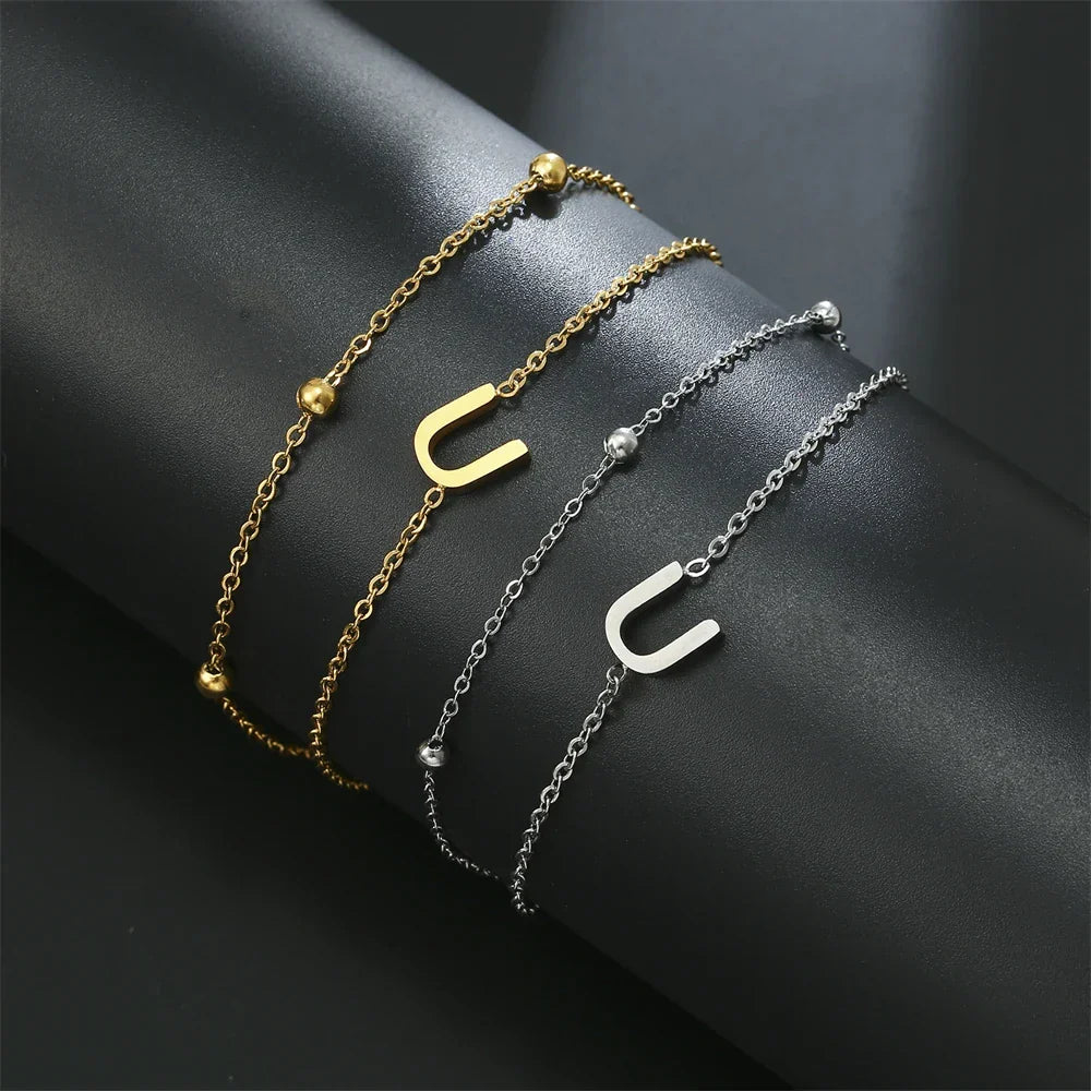 Armband med dubbel initial i guld och silver  u